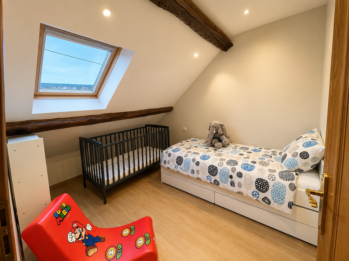 Chambre enfants avec lit bébé à barreaux et deux lits simples — location familiale en Essonne